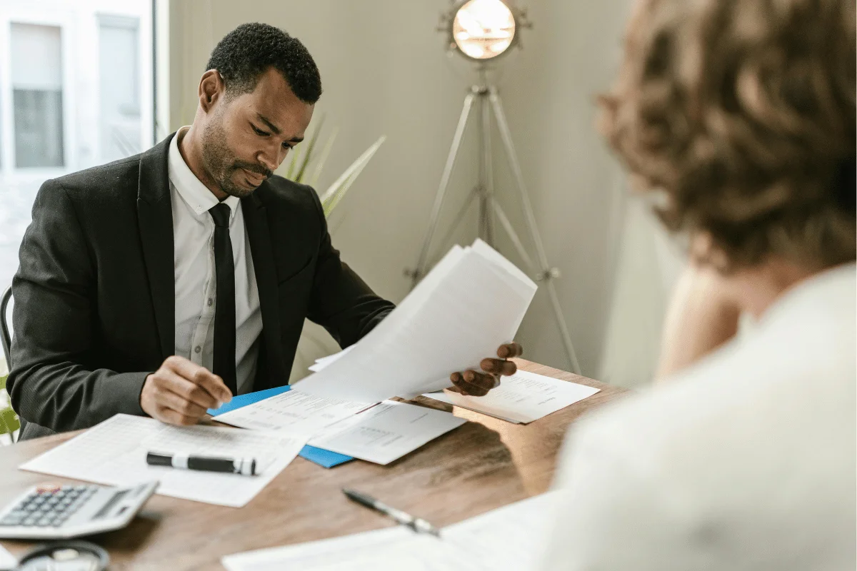 Businessman in a suit reviewing financial documents at his desk.