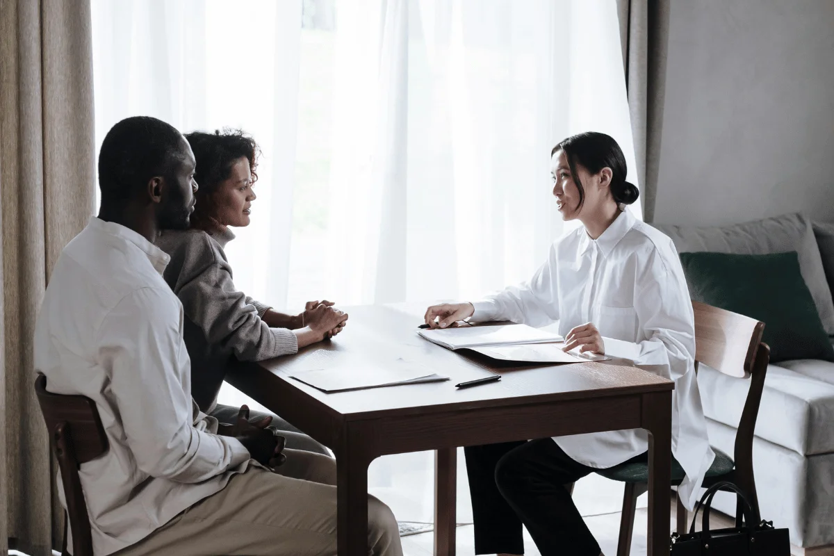 Advisor discussing paperwork with a couple at a table.