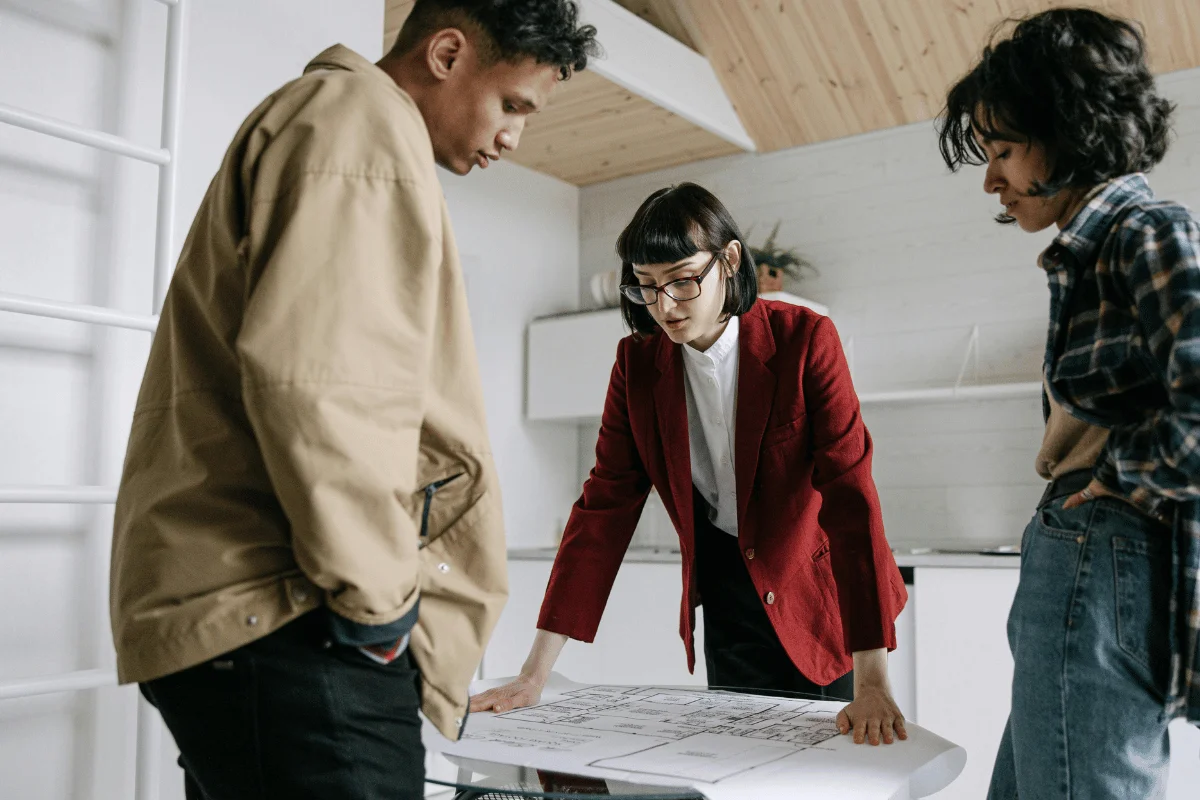 Real estate agent explaining floor plans to clients.