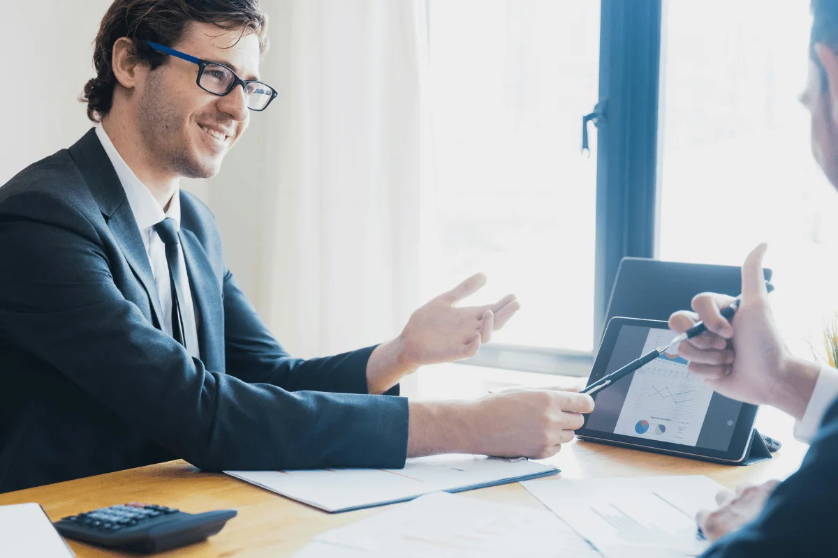 Business meeting with two men in suits at a table.